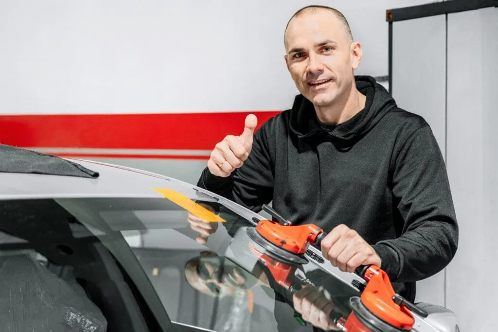 Auto glass technician completing a windshield replacement at Snowline Autoglass